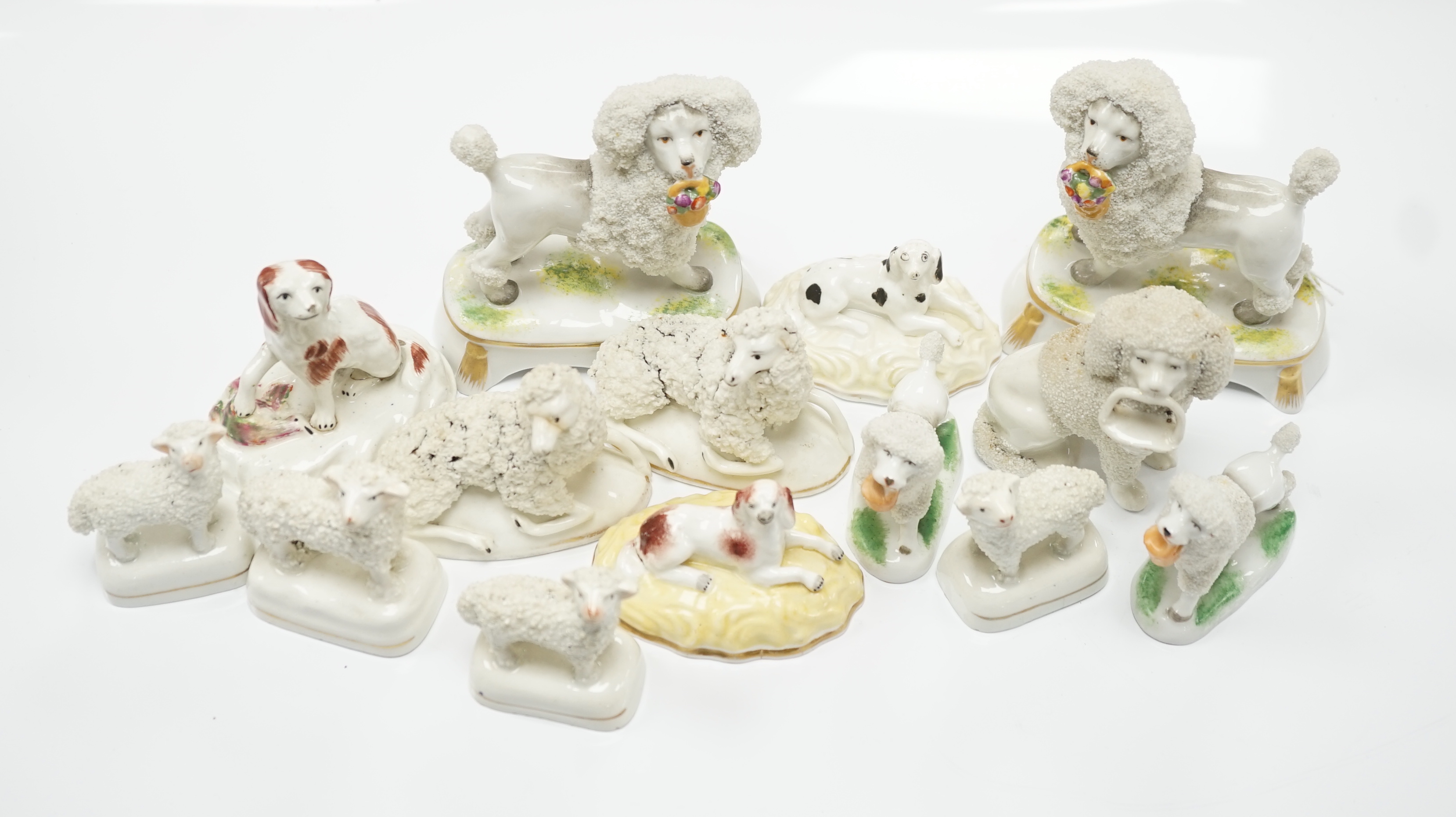 Two Samuel Alcock models of recumbent spaniels, a Staffordshire porcelain model of a seated spaniel and six similar sheep c.1830-50, and five Continental porcelain models of poodles (11)